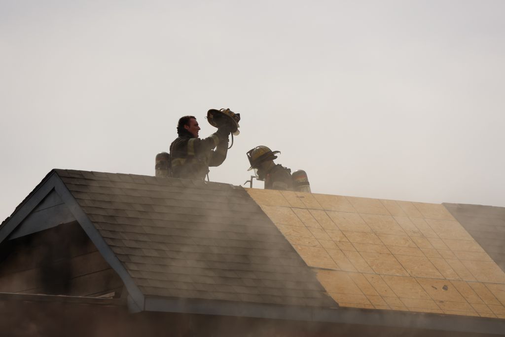 Firefighters do firefighting on the roof of building.