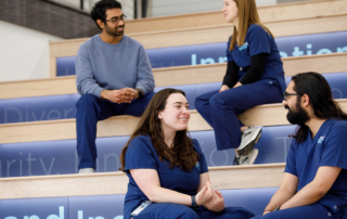 Four KansasCOM students chat on risers