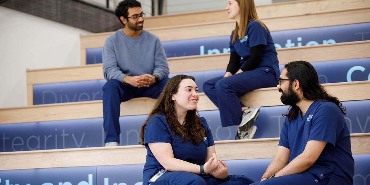 Four KansasCOM students chat on risers