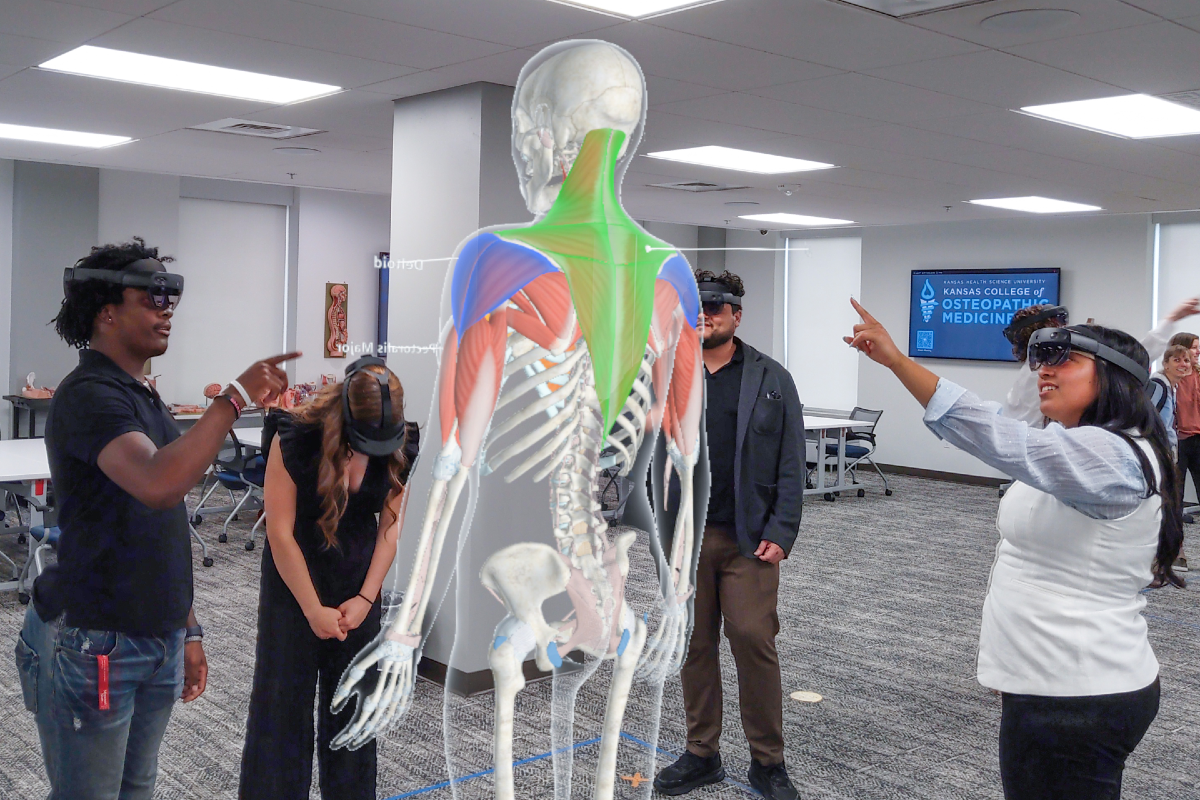 Rodrigo Carrizales and his students examine muscle groups using a holographic anatomy model at KansasCOM.