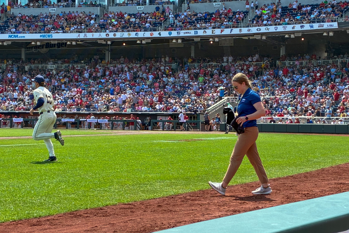 Nicole Terpack walks onto the field at the College World Series as part of a KansasCOM student learning experience.